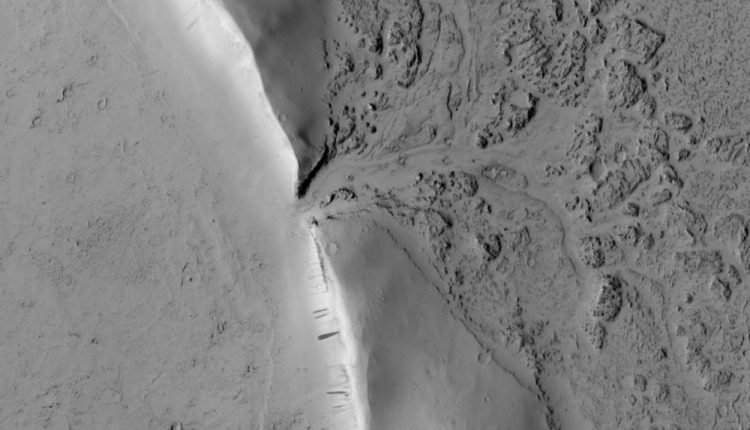 You can see the point where lava broke through the wall of a Martian crater and began to fill it in

