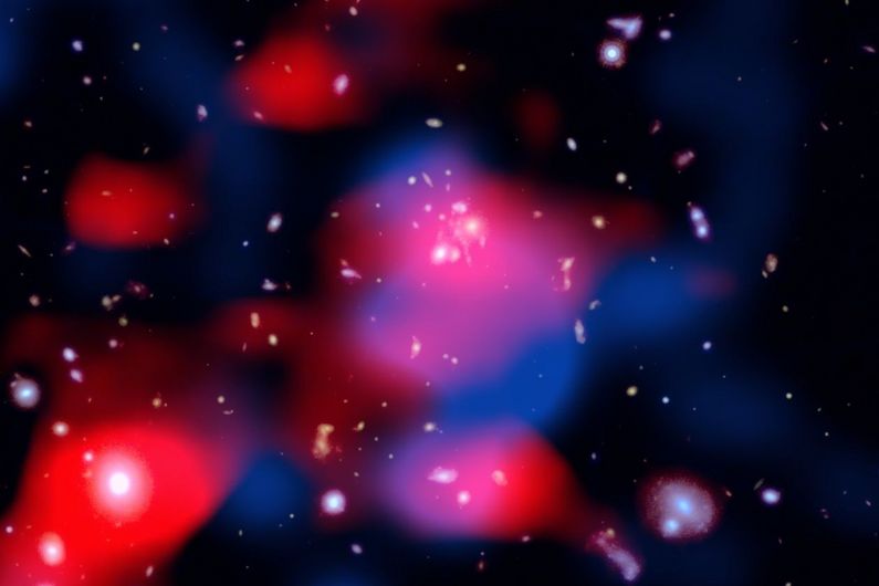 This stunning image reveals a distant galaxy cluster teeming with energy: galaxies shine in visible light (white), ghostly red clouds unveil a newly discovered radio mini-halo—the most distant ever detected—and blue wisps trace the hot gas glowing in X-rays. Credit: X-ray: NASA/CXC/SAO; Optical: NASA/ESA/STScI; Radio: ASTRON/LOFAR; Image Processing: NASA/CXC/SAO/N. Wolk