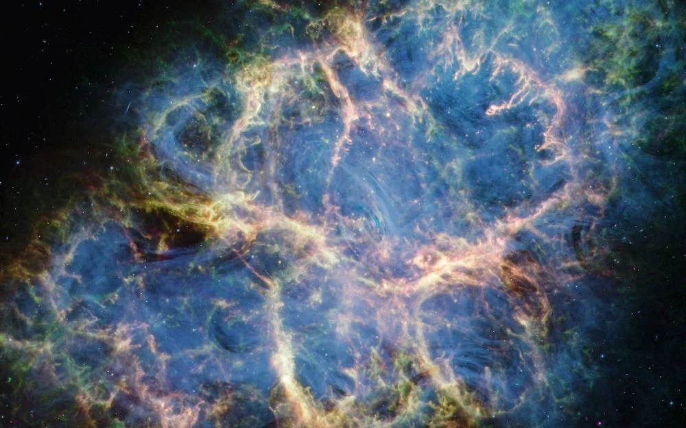 The Crab Nebula is one of the most well-studied objects in astronomy. A pulsar is in the center of the nebula, and pulsars emit radio waves. Most pulsar radio emissions are broad and noisy, but the Crab's are in a sort of zebra pattern. New research has figured out why. Image Credit: NASA/JWST
