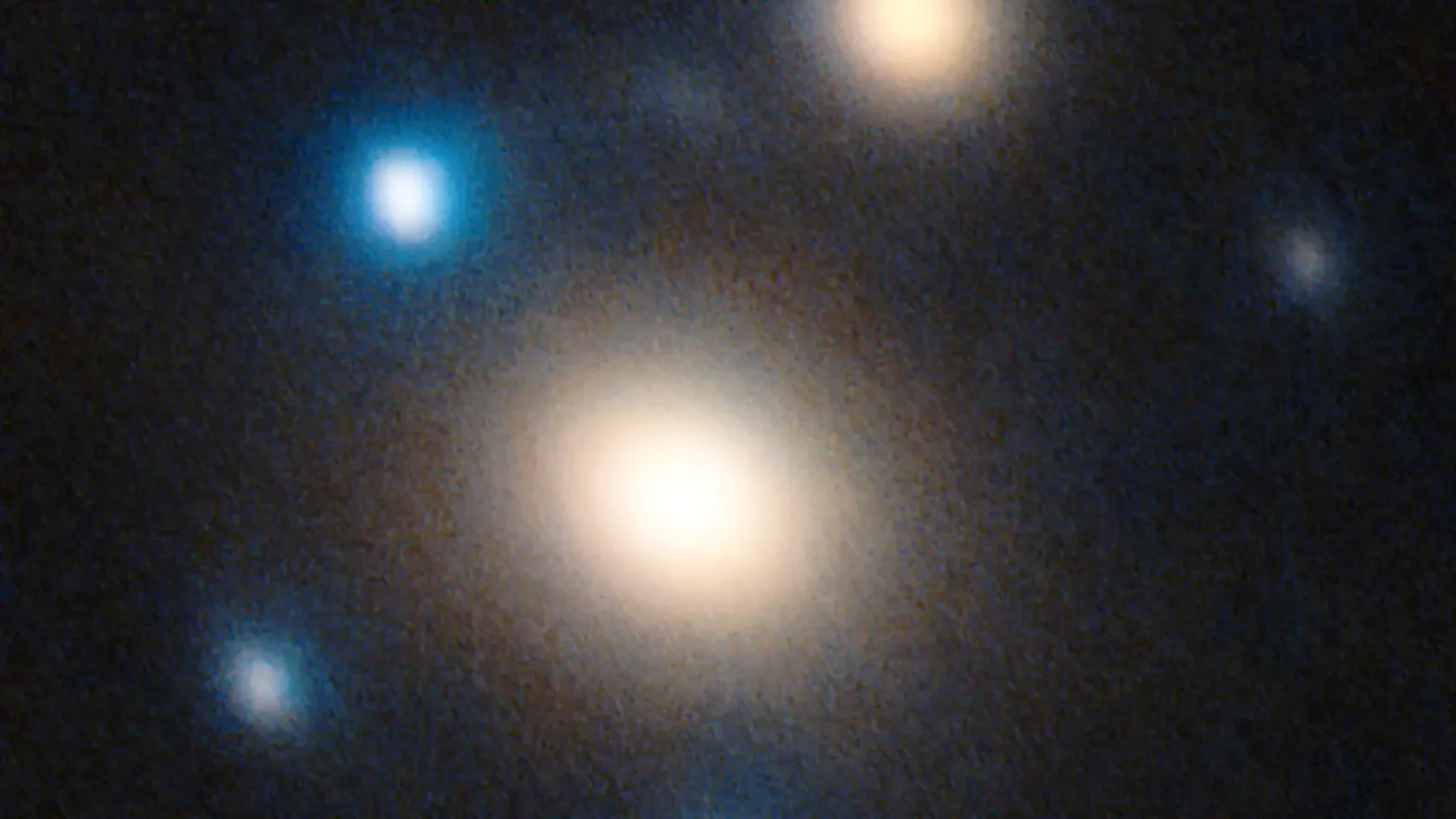 A high-resolution image taken with the LBT in Arizona shows two galaxies in yellow-red. Surrounding them are five images of the same supernova caused by gravitational lensing. Credit &amp; ©: SN Winny